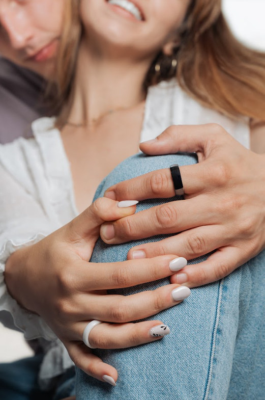 Coppia giovane con PAGO Ring bianco e nero alle dita anello di pagamento NFC per la Gen Z che ha detto addio al contante